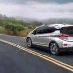 A silver 2020 Chevy Bolt EV is shown driving to view used cars for sale near Florence.