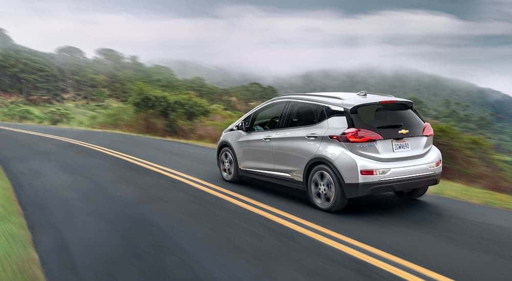 A silver 2020 Chevy Bolt EV is shown driving to view used cars for sale near Florence.