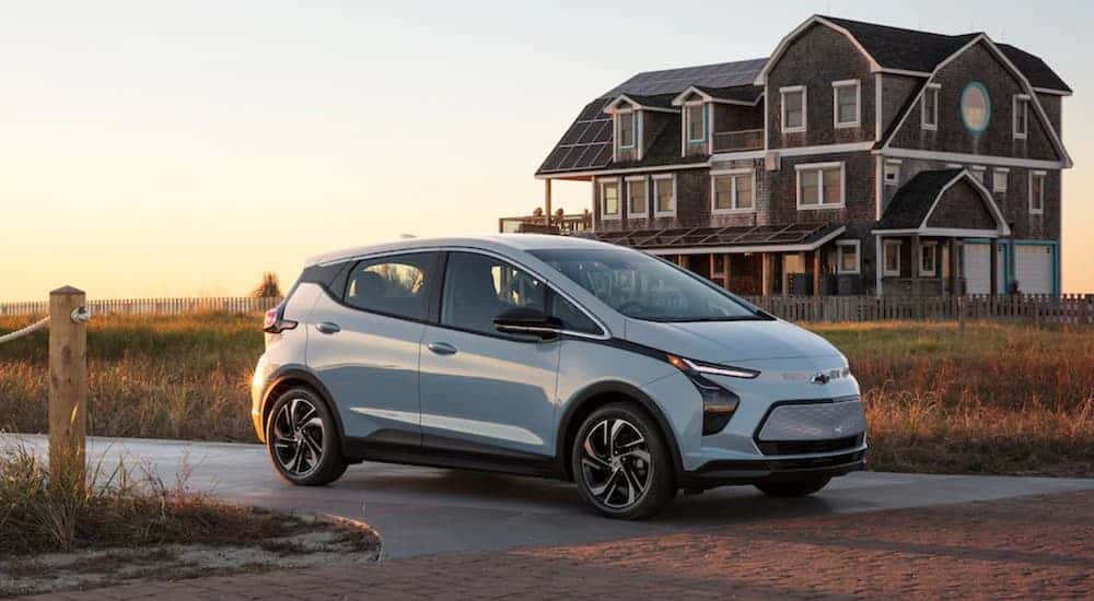 A white 2022 Chevy Bolt EV is shown driving to view used cars for sale near Florence.