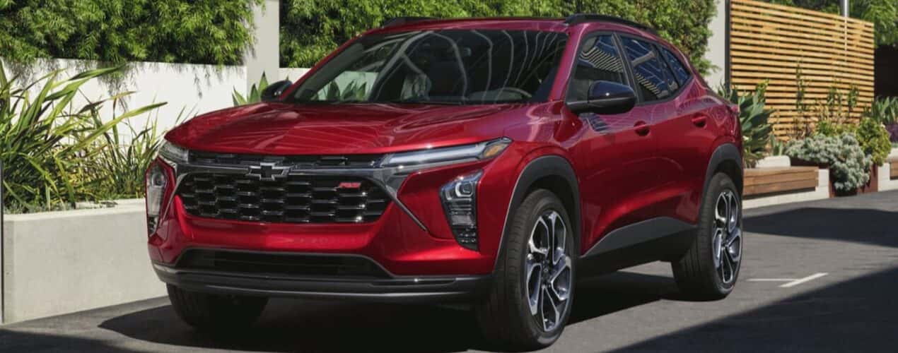 A red 2025 Chevy Trax 2RS is shown parked on a city street.