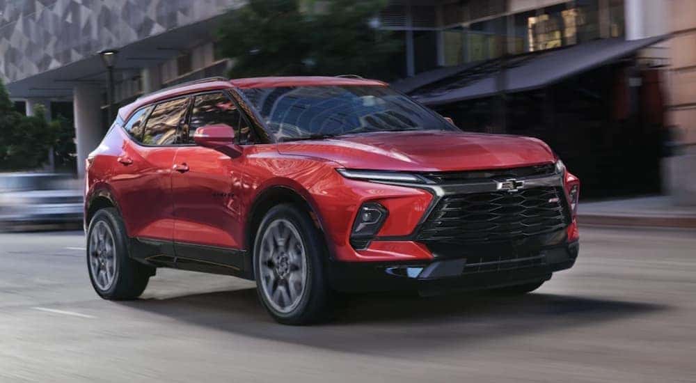 A red 2023 Chevy Blazer RS driving to view used cars for sale near Mason.