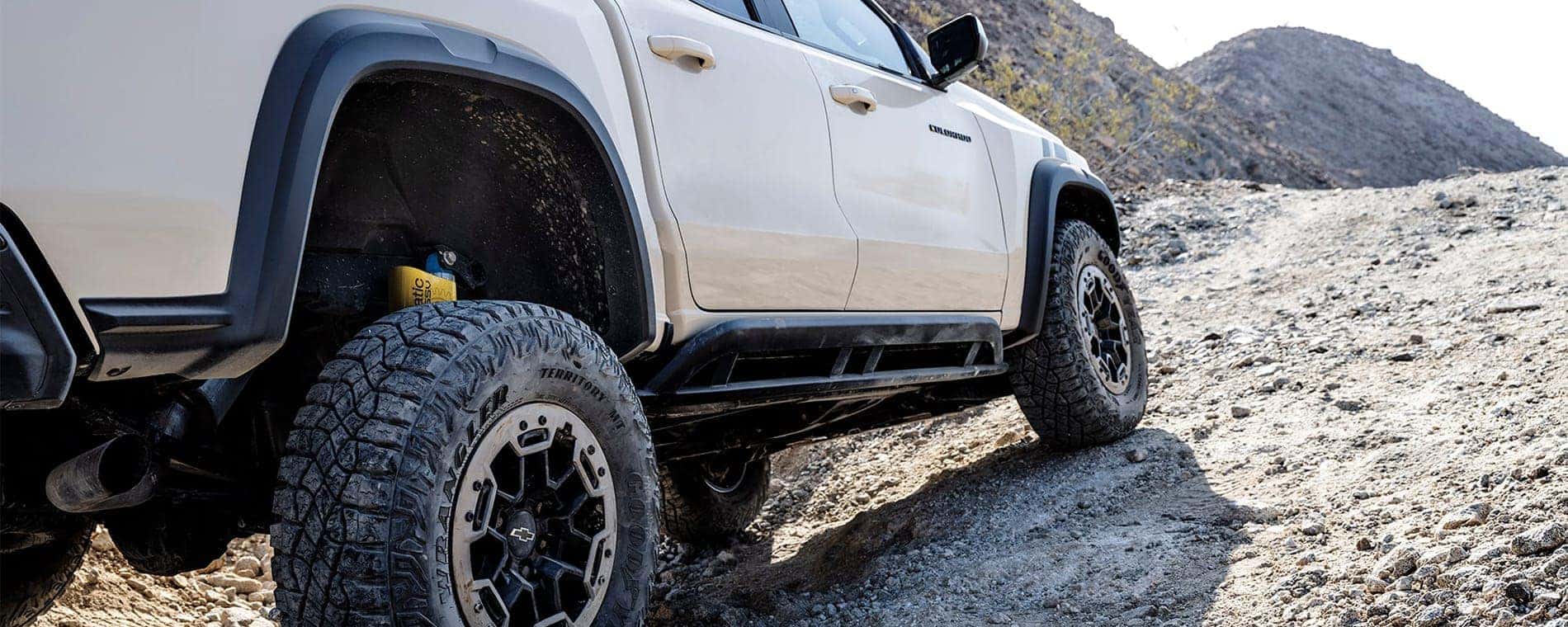 A tan 2025 Chevy Colorado ZR2 is driving off-road.