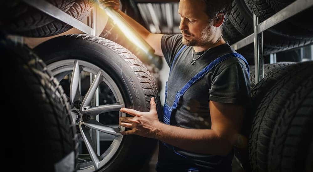 A technician looking at a tire.