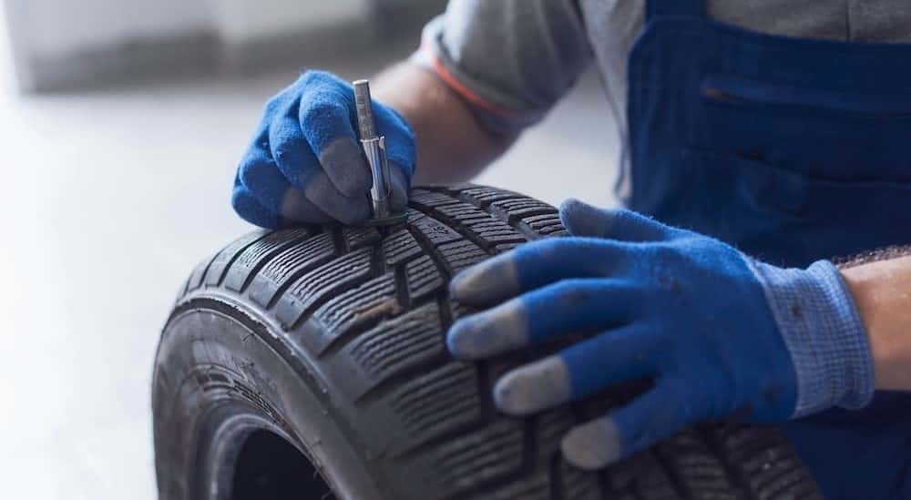 A mechanic checking tire tread at a GMC service near Florence.