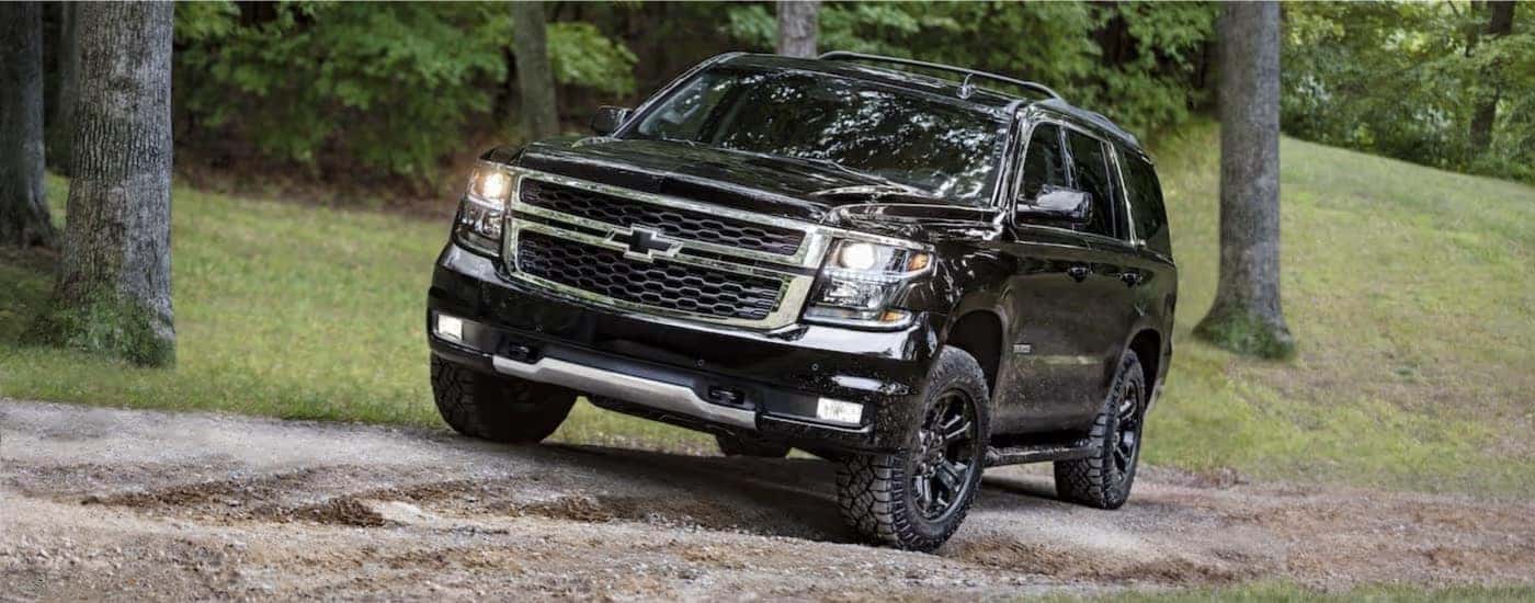 A black 2017 Chevy Tahoe is parked on a dirt lot.