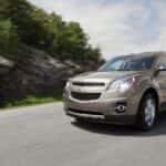 A tan 2012 Chevy Equinox driving on a highway.