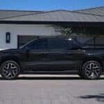 A black 2025 Chevy Silverado EV parked on a driveway.