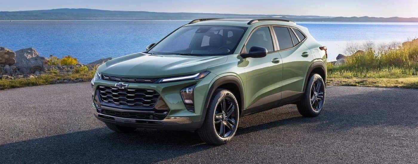 A green 2025 Chevy Trax ACTIV parked near a lake.