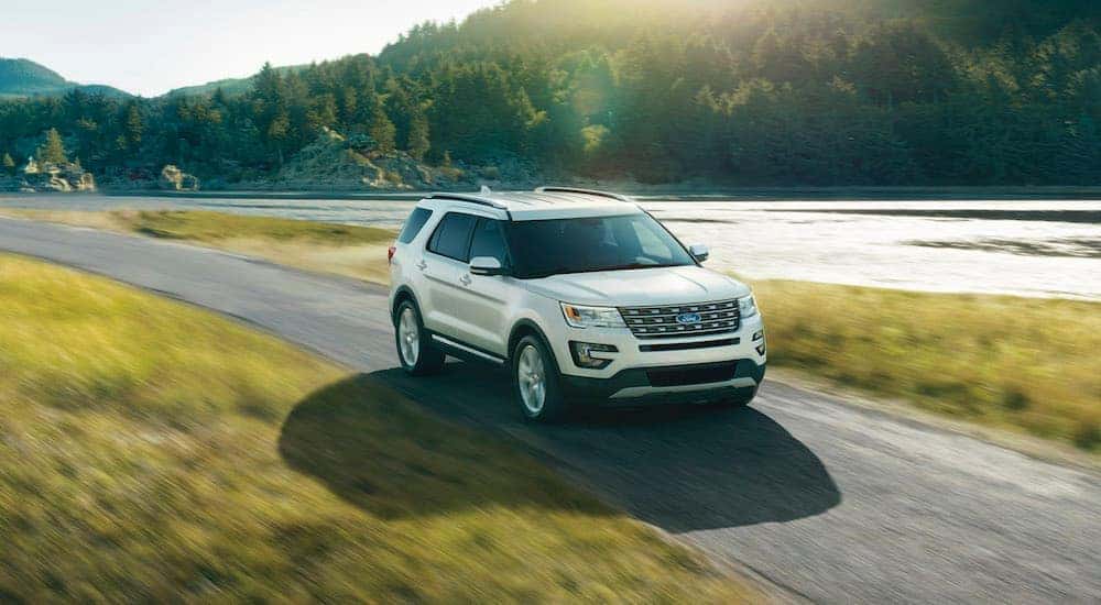 White 2016 Ford Explorer driving down a road.