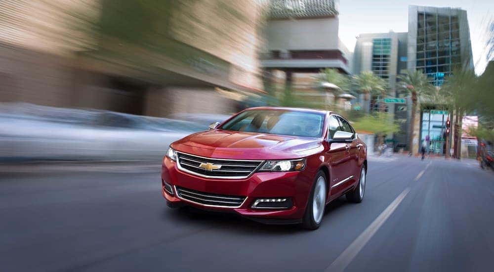Red 2018 Chevy Impel LTZ driving down an city street.