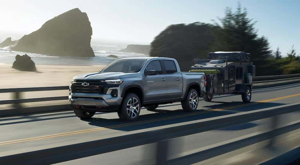 A silver 2025 Chevy Colorado Z71 towing a trailer on a highway.