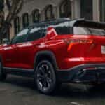 A red 2025 Chevy Equinox RS parked in a city.