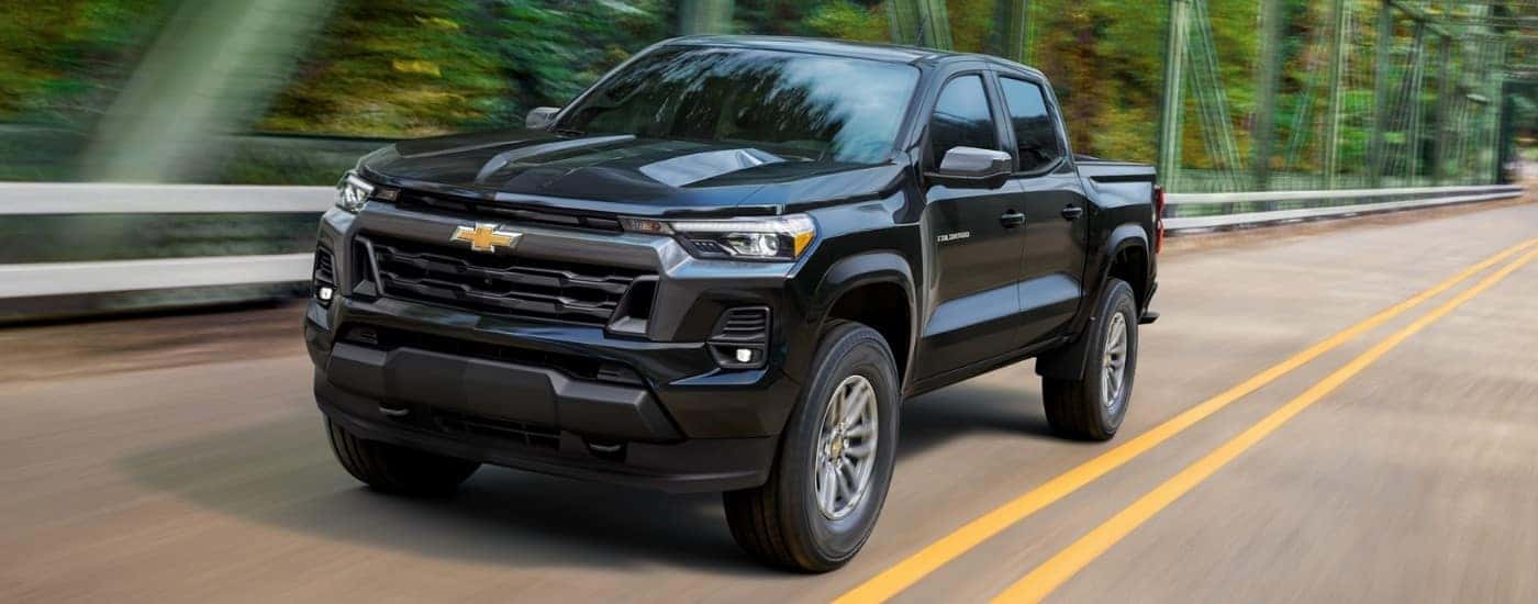 A black 2025 Chevy Colorado driving over a bridge.
