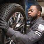 A Certified GMC master technician putting on a tire