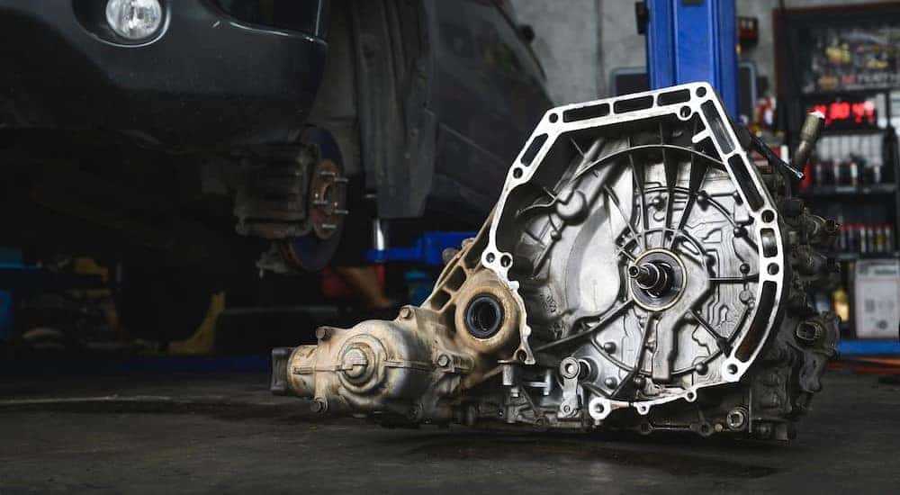 A transmission on the floor of a garage.
