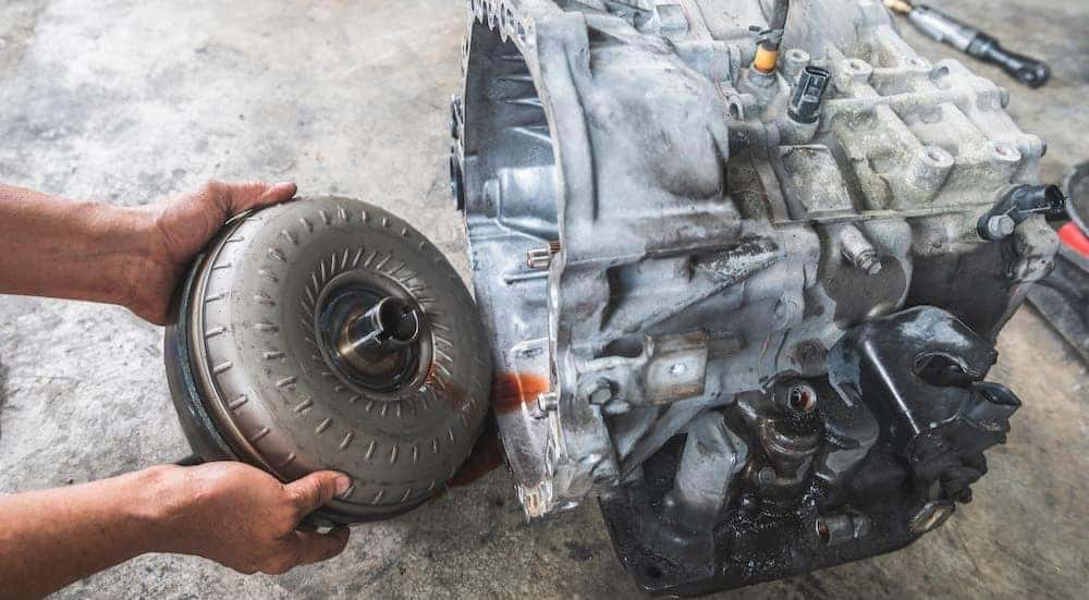 Mechanic removing the torque converter from the automatic transmission.