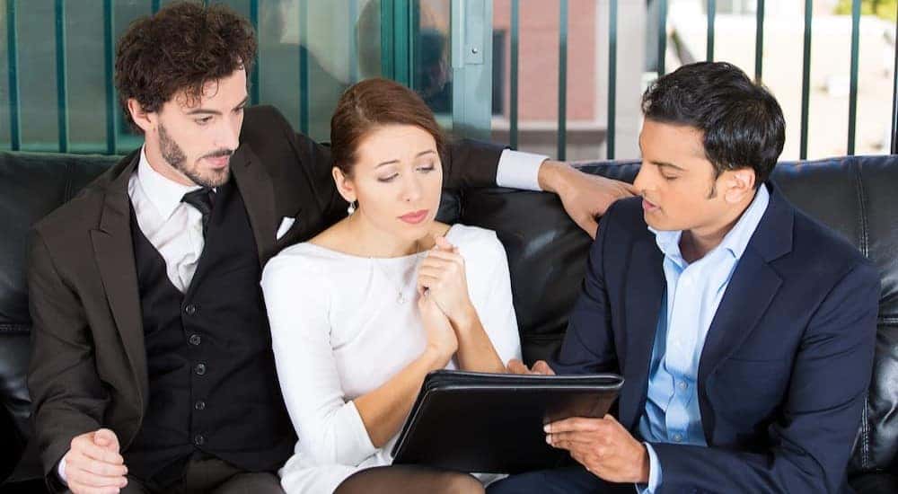 Three people using a tablet.