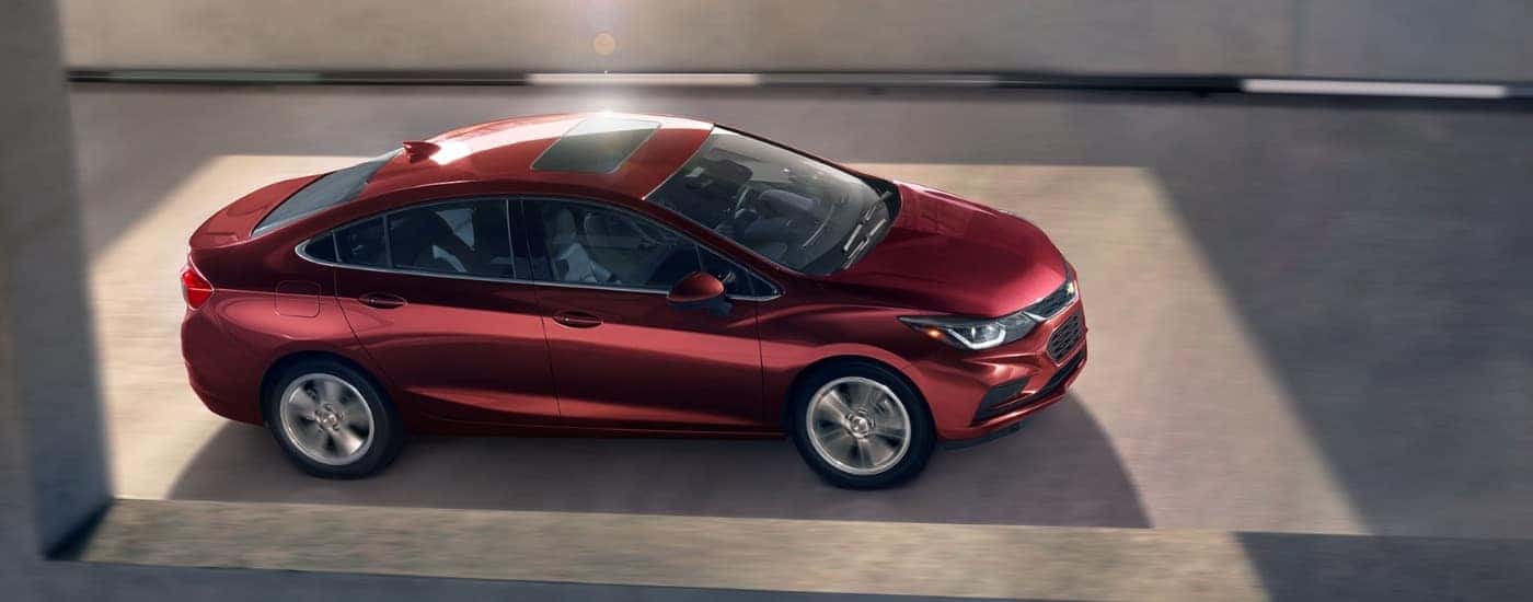 A maroon 2016 Chevy Cruze driving to look at used cars for sale near Covington.