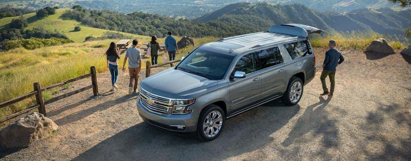 A grey 2019 Chevy Suburban near picnic tables.