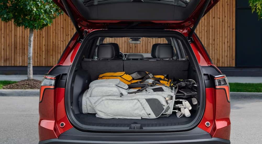 Golf clubs in the rear cargo area in a red 2026 Chevy Equinox.