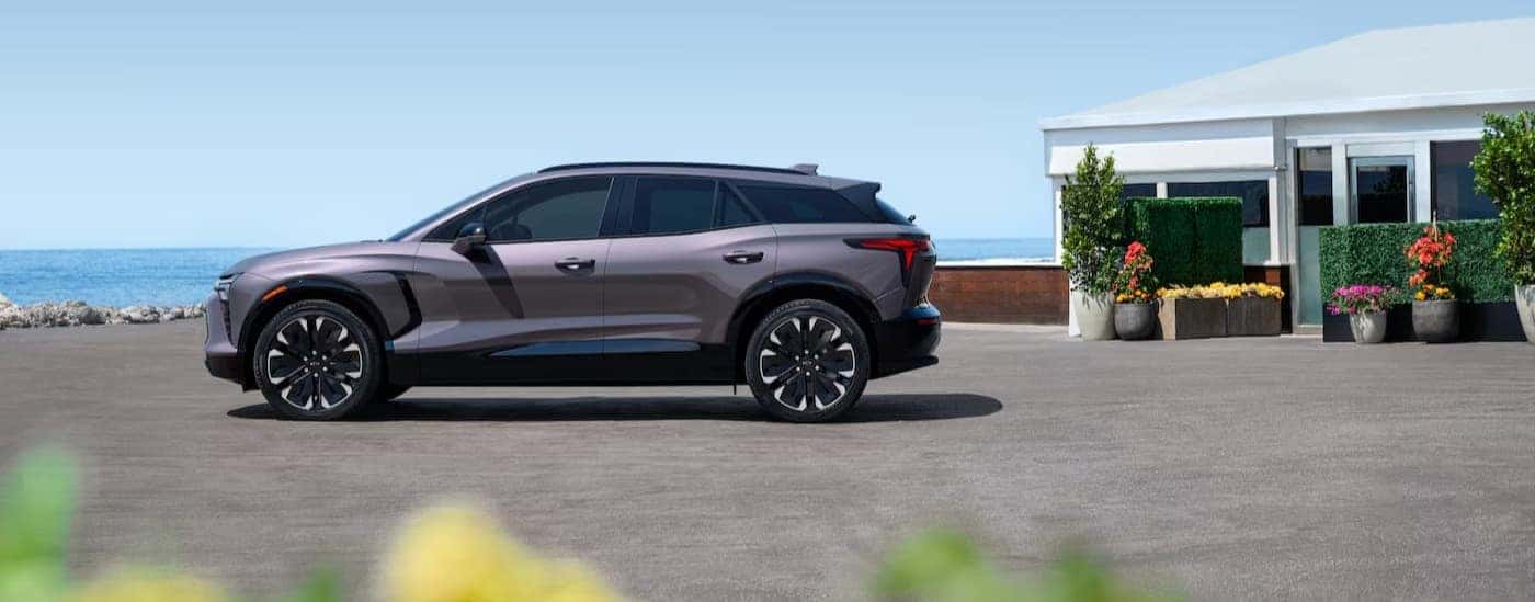 A gray 2025 Chevy Blazer EV parked near an ocean.