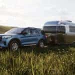 A blue 2025 Ford Explorer Active towing a trailer.