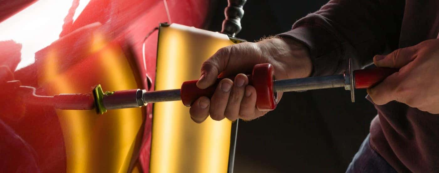 A technician repairing a dent.