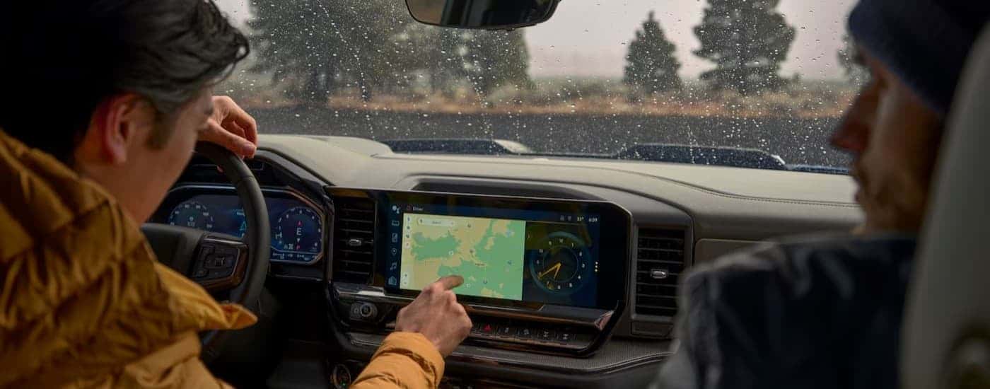 A person using an infotainment screen in a 2025 Chevy Silverado 1500 RST.