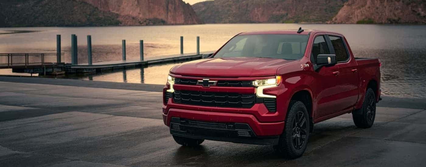 A red 2025 Chevy Silverado 1500 RST Z71 parked near a lake.