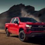 A red 2025 Chevy Silverado 1500 Z71 Trail Boss parked off-road.