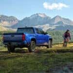 A blue 2025 Toyota Tacoma from the rear at an angle after leaving a Toyota service center near Covington.