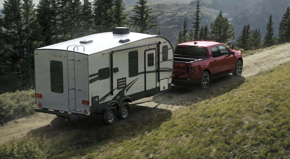 A red 2025 Ford Maverick towing a trailer to a Ford service center near Covington.