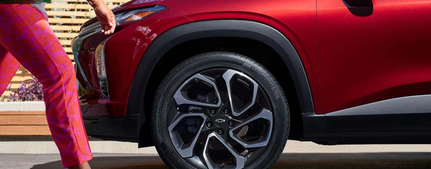 Side of a red 2025 Chevy Trax in a city