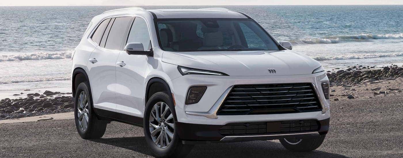 White 2025 Buick Enclave parked on a beach.