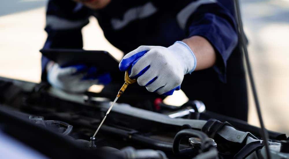 Mechanic checking an oil stick at a Buick service center near Mason
