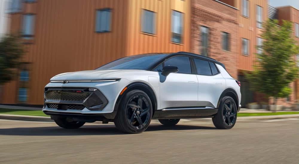 White 2025 Chevy Equinox EV RS driving on a city street