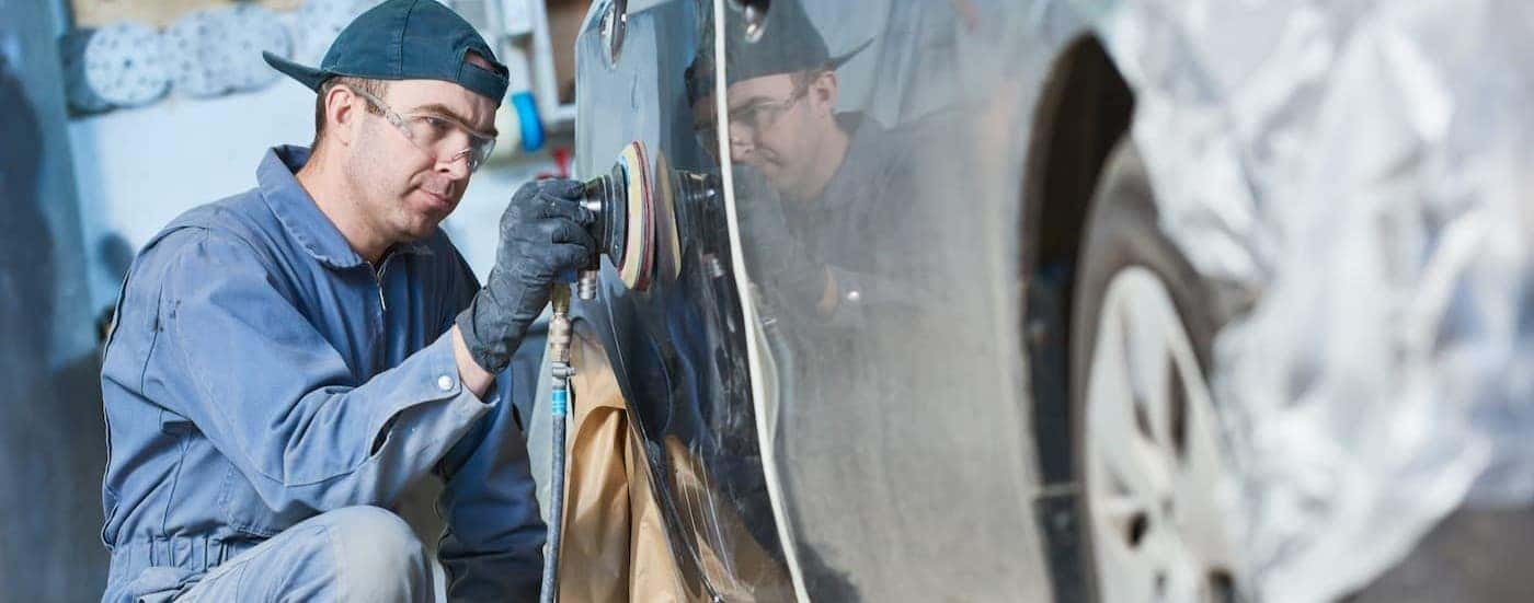 A technician sanding a car.
