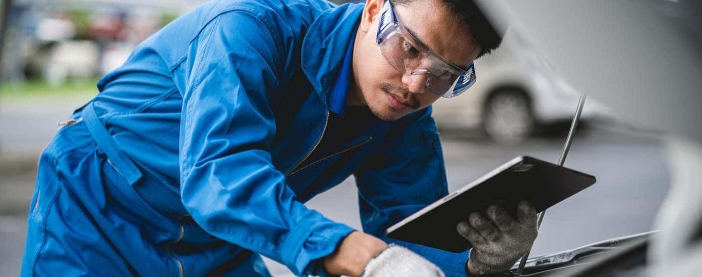 A technician inspecting an engine at a GMC service center near Mason.