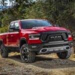 Red 2019 Ram 1500 driving off-road from a dealer with a used trucks for sale near Mason.