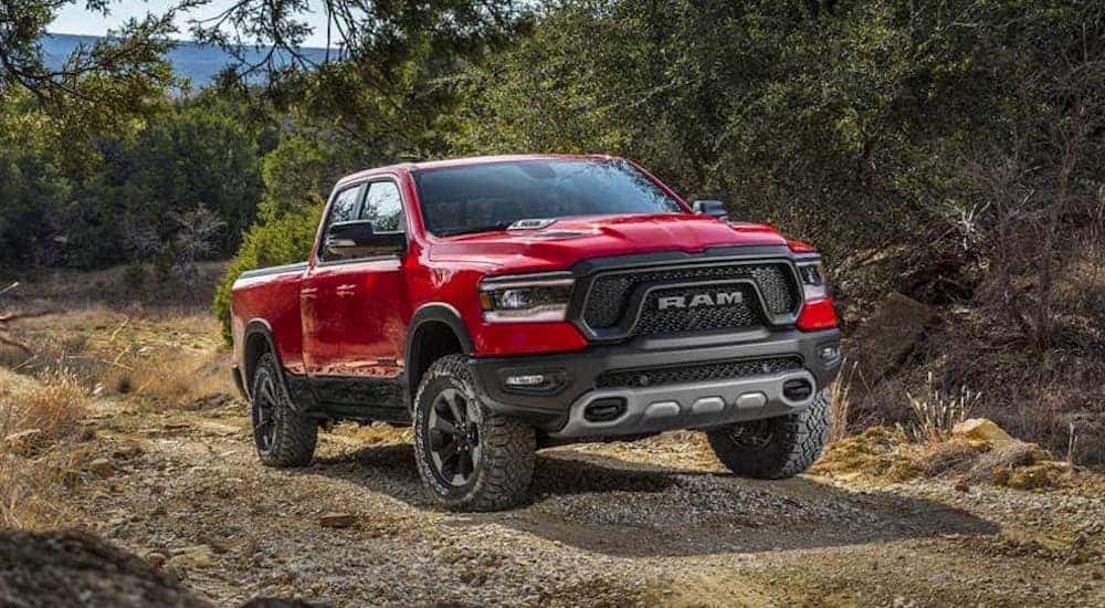 Red 2019 Ram 1500 driving off-road from a dealer with a used trucks for sale near Mason.