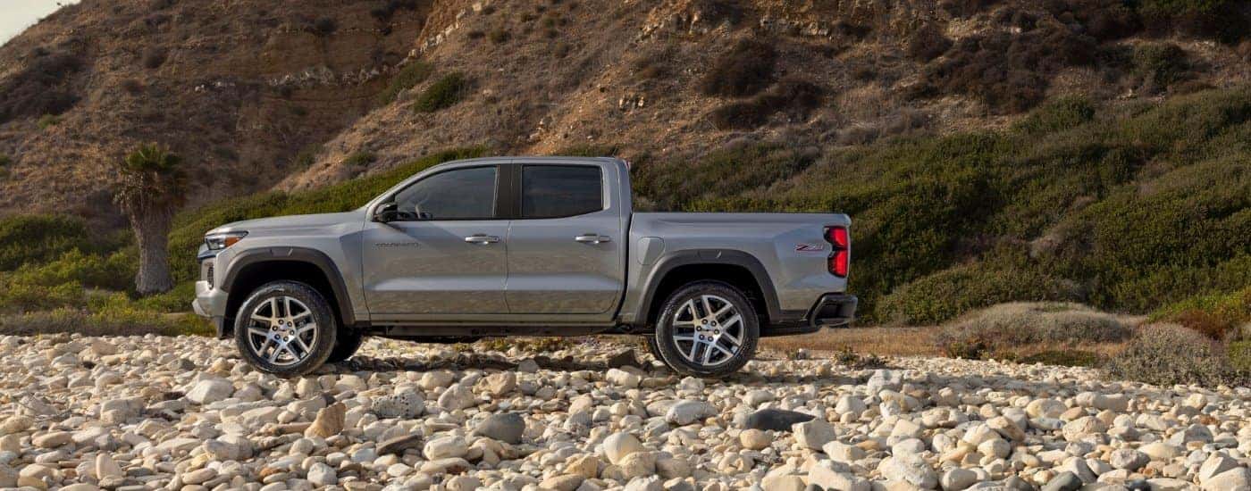 A silver 2023 Chevy Colorado from the side after leaving a dealer that has a used Chevy for sale.