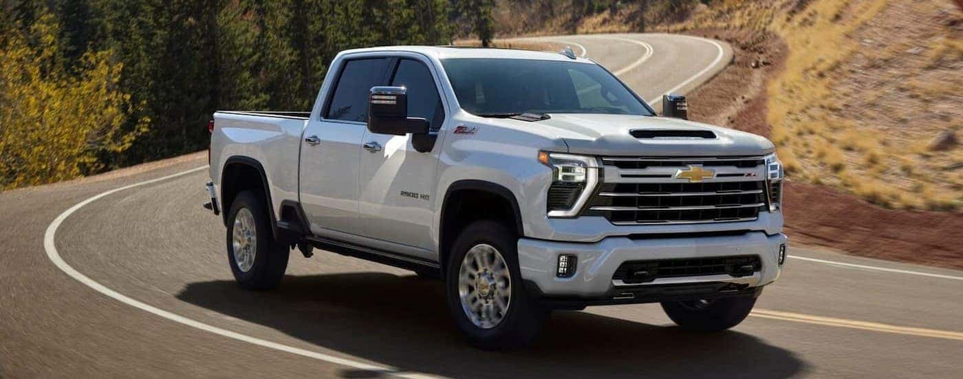 A white 2025 Chevy Silverado 2500 driving on a highway.
