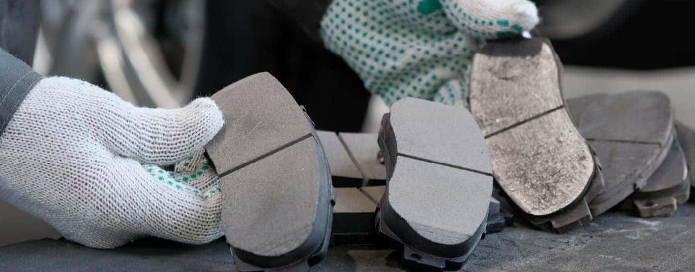 A technician holding brake pads.