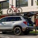 Silver Honda Passport parked on a city street as people load the trunk.