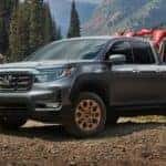 2021 dark grey Honda Ridgeline parked on a mountain with two dirt bikes in the bed.