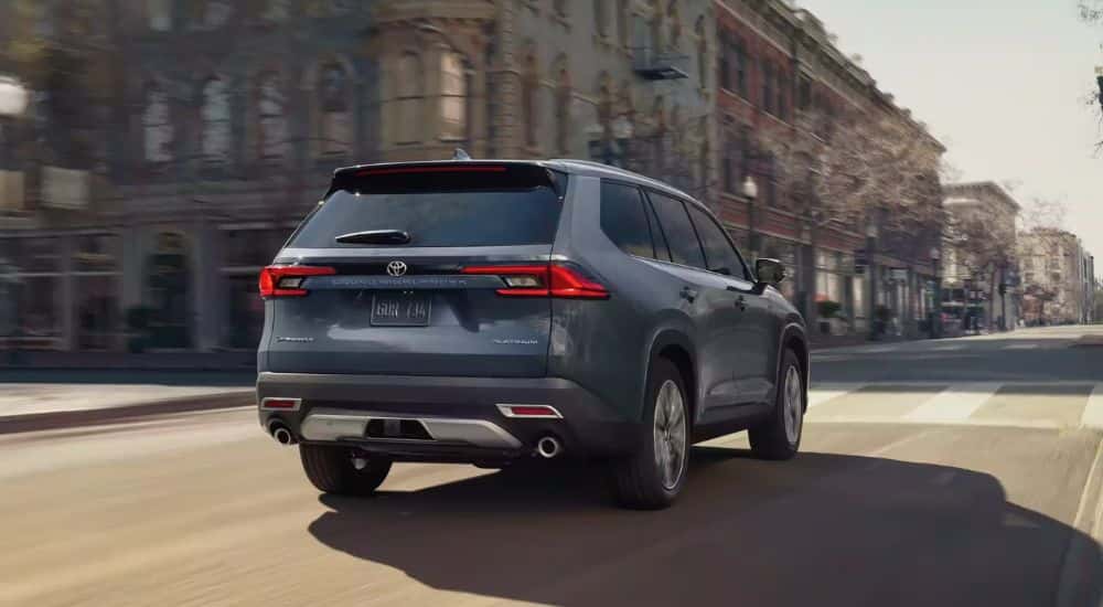 2024 Toyota Grand Highlander driving away from a service center near Mason.