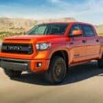 Orange 2015 Toyota Tundra driving off-road.