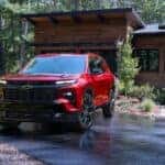 Red 2024 Chevy Traverse RS leaving a driveway to look at used Chevys for sale in Cincinnati