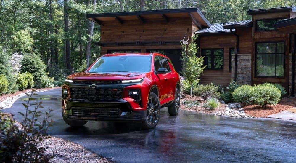 Red 2024 Chevy Traverse RS leaving a driveway to look at used Chevys for sale in Cincinnati