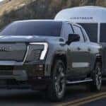 Silver 2026 Chevy Silverado EV towing a camper